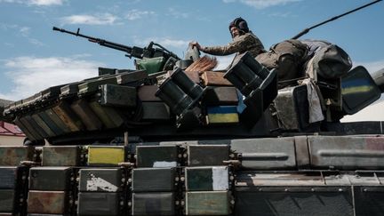 Un soldat ukrainien est assis sur un char près de Bakhmut, dans l'est de l'Ukraine, le 12 mai 2022. (YASUYOSHI CHIBA / AFP)