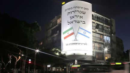 Dans le centre de Tel Aviv, une affiche géante annonce l'ouverture d'une ambassade d'Iran. Elle fait partie de la campagne de promotion de la comédie "Atomic Falafel" (27 août 2015).
 (Ahmad Gharabli / AFP)