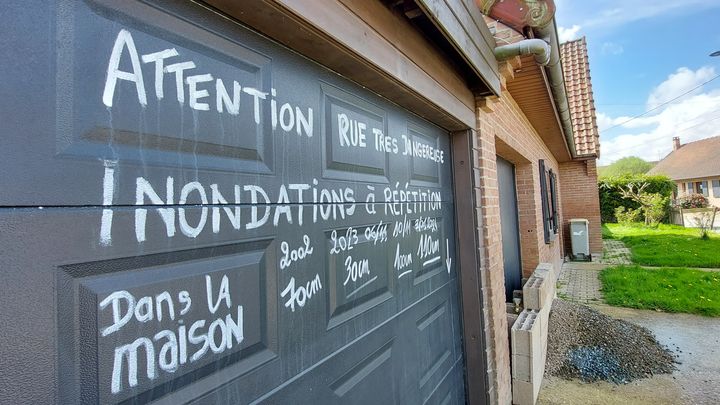 Message laissé sur une porte de garage impasse Salengro à Blendecques (Pas-de-Calais), quartier inondé en novembre 2023 et janvier 2024 (BENJAMIN ILLY / RADIO FRANCE)