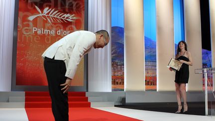 Le réalisateur thaïlandais Apichatpong Weerasethakul au moment de recevoir sa palme d'or pour "Oncle Boonmee, celui qui se souvient de ses vies antérieures", le 23 mai&nbsp;2010 à Cannes. (VALERY HACHE / AFP)