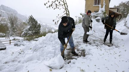 Des habitants de Valfleury, pr&egrave;s de Saint-Etienne (Loire), d&eacute;gagent la neige accumul&eacute;e&nbsp;devant leur maison, le 20 novembre 2013. (PHILIPPE DESMAZES / AFP)