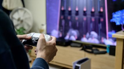 Un jeune homme joue sur sa Playstation, à Séoul, le 12 novembre 2020. (YELIM LEE / AFP)