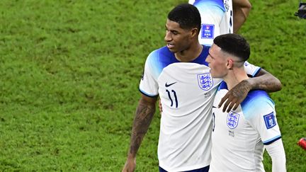 Les joueurs anglais Marcus Rashford et Phil Foden célèbrent leur victoire face au pays de Galles, en Coupe du monde, le 29 novembre 2022. (JAVIER SORIANO / AFP)