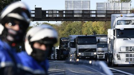 Des policiers encadrent une opération escargot de forains qui protestent contre l'annulation du marché de Noël de Marcel Campion sur les Champs-Elysées, en banlieue parisienne le 6 novembre 2017. (PHILIPPE LOPEZ / AFP)