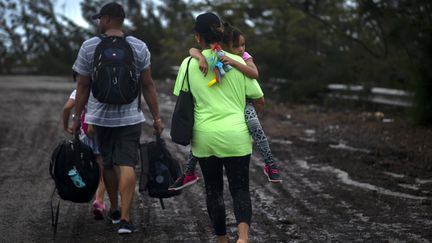 Cette famille, résidant sur l'île de Grande Bahama, a été secourue, le 3 septembre 2019, par des volontaires qui ont réussi à conduire un bus à travers les rues inondées.&nbsp; (RAMON ESPINOSA / AP / SIPA)