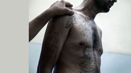 Un chabiha (membre de la milice syrienne pro-gouvernementale) est détenu par des rebelles dans la prison de Marea, le 1er août 2012. 

Il arbore sur son torse des tatouages à la gloire du clan Assad.

L’écrivain et opposant syrien, Yassin al-Haj Saleh, a écrit un essai sur cette milice.

Il vit aujourd’hui dans la clandestinité. (Laurent Van der Stockt pour Le Monde)