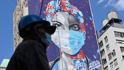 Un passant circule devant une fresque, le 7 mai 2020 à New York (Etats-Unis). (ANGELA WEISS / AFP)