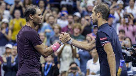 Rafael Nadal (gauche) et Richard Gasquet (droite) se serrent la main après la victoire de l'Espagnol lors du 3e tour de l'US Open 2022, le 3 septembre. (COREY SIPKIN / AFP)