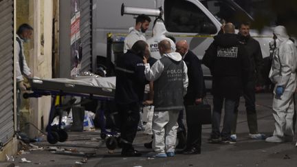 Des policiers évacuent un corps après l'intervention antiterroriste à Saint-Denis (Seine-Saint-Denis), le 18 novembre 2015. (ERIC FEFERBERG / AFP)