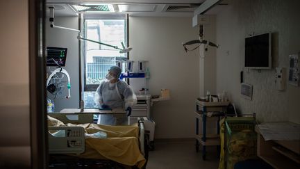 Un médecin discute avec une patiente infectée par le Covid-19 au service de réanimation de l'hôpital Saint-Louis de l'AP-HP, à Paris le 28 mai 2020 (photo d'illustration). (MARTIN BUREAU / AFP)