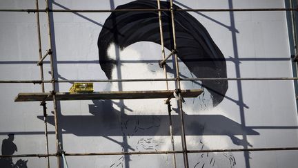 Un &eacute;chafaudage masque un portrait inachev&eacute; de l'ancien leader iranien l'ayatollah Khomeini peint sur un immeuble de T&eacute;h&eacute;ran (Iran), le 26 f&eacute;vrier 2012. (BEHROUZ MEHRI / AFP)