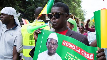 Un militant&nbsp;tient une affiche sur laquelle figure l'opposant malien Soumaïla Cissé, lors d'une marche de protestation contre les résultats de la présidentielle au Mali, le 1er septembre 2018, à Bamako.&nbsp; (ANNIE RISEMBERG / AFP)