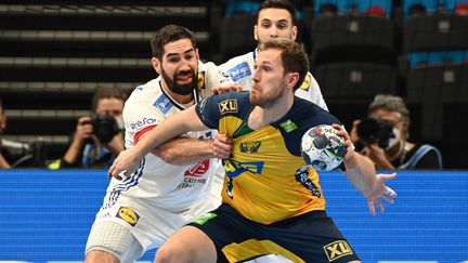 Nikola Karabatic au duel avec Linus Persson pendant la demi-finale du Championnat d'Europe, le 28 janvier 2022. (ATTILA KISBENEDEK / AFP)