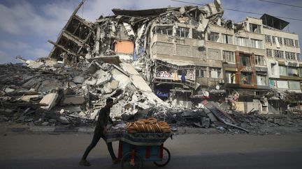 Un homme passe devant&nbsp;un bâtiment détruit par des frappes israéliennes, dans la ville de Gaza, le 20 mai 2021. (MAHMUD HAMS / AFP)