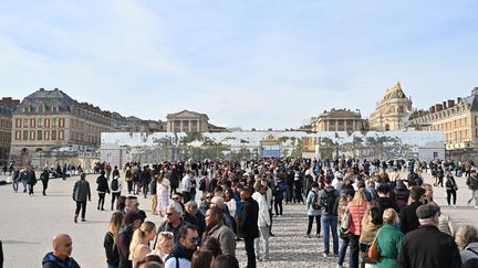 Des visiteurs du château de Versailles patientent devant l'enceinte après son évacuation, lors d'une alerte à la bombe, le 17 octobre 2023. (MUSTAFA YALCIN / ANADOLU via AFP)