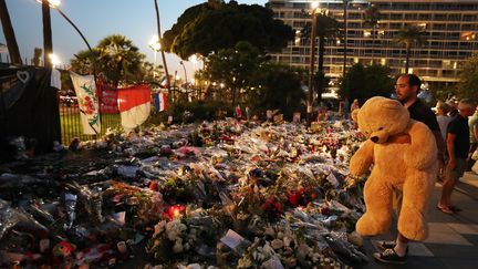 Un homme&nbsp;rend hommage aux victimes de l'attentat de Nice, le 19 juillet 2016 sur la Promenade des Anglais. (VALERY HACHE / AFP)