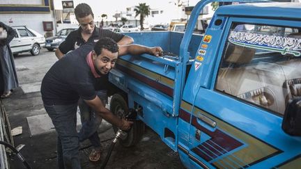 Le geste qui coûte cher en Egypte aujourd'hui. Le gouvernement réduit les subventions sur les carburants. Résultat, les prix s'envolent. (KHALED DESOUKI / AFP)