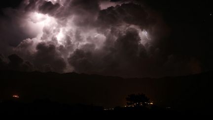 Un éclair lors d'une tempête sur la vallée du Taravo et le village de Petreto-Bicchisano (Corse-du-Sud), le 15 août 2018. (PASCAL POCHARD-CASABIANCA / AFP)