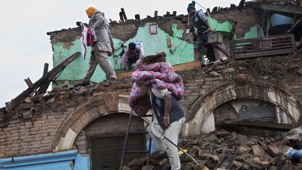 Des survivants essaient alors de r&eacute;cup&egrave;rer des couvertures, des draps ou encore des matelas dans les d&eacute;combres. (BERNAT ARMANGUE / AP / SIPA)