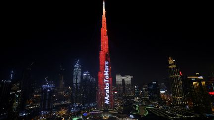 Le Burj Khalifa de Dubaï est éclairé en rouge le 9 février 2021 alors que la sonde des Emirats Arabes Unis "Amal" - en arabe pour "Hope" - effectue une manœuvre délicate pour entrer sur l'orbite de la planète rouge. (GIUSEPPE CACACE / AFP)