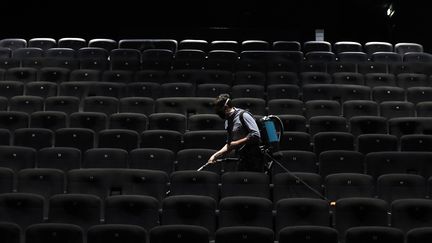 Un employé nettoie la salle d'un cinéma du groupe&nbsp;CGR à Cagnes-sur-Mer le 22 juin 2020. Photo d'illustration. (SEBASTIEN NOGIER / EPA)