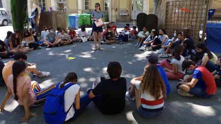 Collégiens en rond autour d'Agathe, animatrice, pour le bilan de leur séjour au Festival d'Avignon.&nbsp; (JEREMIE LAURENT-KAYSEN)