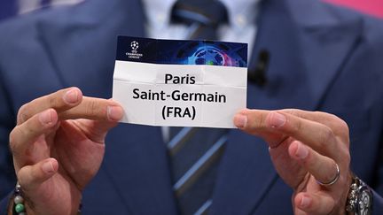 Hamit Altintop montre le papier du PSG durant le tirage au sort des huitièmes de finale de la Ligue des champions, le 7 novembre 2022 à Nyon (Suisse). (FABRICE COFFRINI / AFP)