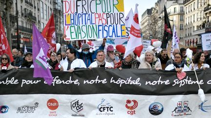 Des soignants tiennent une banderole "ensemble pour défendre notre hopital et notre système de santé" lors d'une manifestation à Paris, le 14 février 2020. (STEPHANE DE SAKUTIN / AFP)