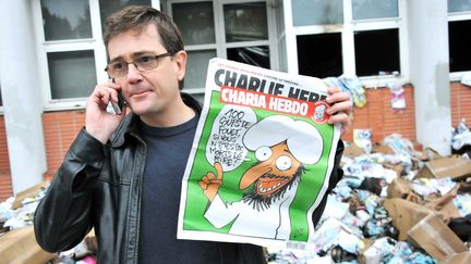 Charb en 2011, devant les locaux du Charlie Hebdo détruits par un cocktail Molotov. L'incendie était criminel : le journal s'appretait a sortir cette semaine un numero special, rebaptisé pour lÍoccasion " Charia hebdo".
 (URMAN LIONEL/SIPA )