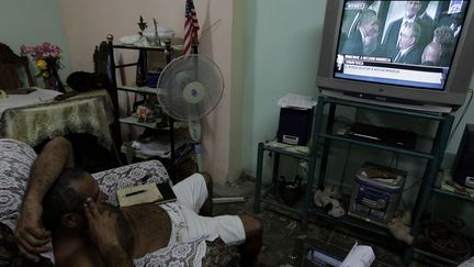 Un Cubain assiste depuis la Havane à la poignée de mains échangée par Barack Obama et Raul Castro à Soweto, en décembre 2013. (Enrique De La Osa / Reuters)