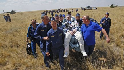 L'astronaute am&eacute;ricain Don Pettit (C) est transport&eacute; par du personnel m&eacute;dical de la Nasa apr&egrave;s avoir atterri &agrave; bord de la capsule Soyouz TMA-03M pr&egrave;s de Zezkazgan (Kazakhstan), le 1er juillet 2012. (REUTERS)