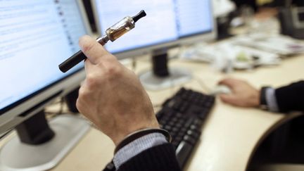 Un vapoteur dans son bureau &agrave; Paris, le 5 mars 2013. (KENZO TRIBOUILLARD / AFP)