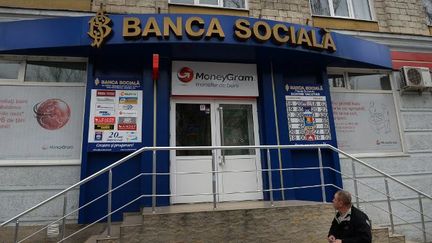 Un homme regarde une agence de la Banque Sociale à Chisinau, en Moldavie, le 27 mars 2015.  (AFP PHOTO / DANIEL MIHAILESCU)