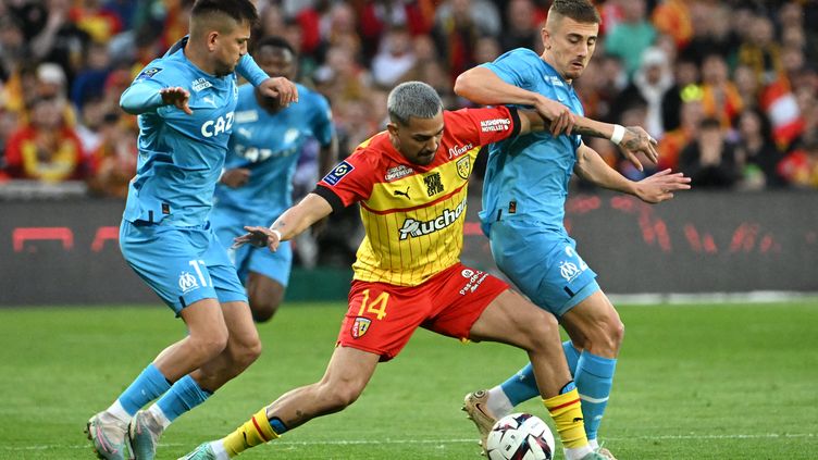 The Lensois Facundo Medina in the fight with the Marseillais Cengiz Ünder and Valentin Rongier in Ligue 1, May 6, 2023. (DENIS CHARLET / AFP)