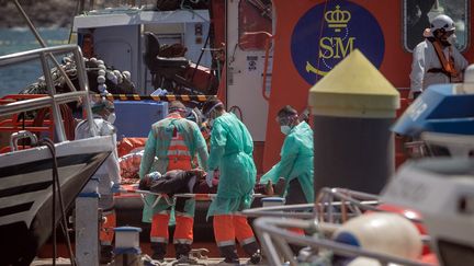 Une femme qui avait tenté de rejoindre les Canaries est secourue par du personnel soignant sur l'île de Tenerife (Espagne), le 26 mars 2021. (DESIREE MARTIN / AFP)