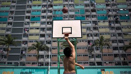 Un jeune homme joue au basket sur un terrain de Hongkong (Chine), le 19 f&eacute;vrier 2013. (LAM YIK FEI / GETTY IMAGES)