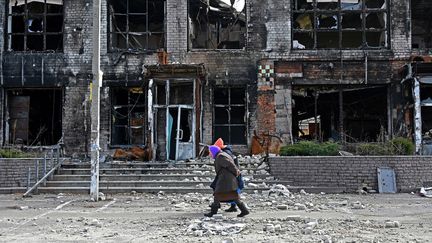 Des passants dans la ville de Tsirkuny (Ukraine), le 20 mars 2023. (SERGEY BOBOK / AFP)