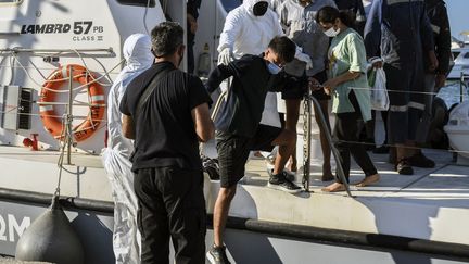 Des migrants débarquent au port de Iérapetra, en Crète (Grèce), le 23 juillet 2021. (JASON TAVLAS / AFP)