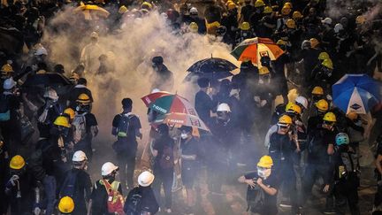 La police lance des gaz lacrymogènes sur des manifestants, à Hong Kong, le 21 juillet 2019. (LAUREL CHOR / AFP)