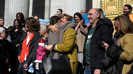 La ministre espagnole chargée de l'Egalité, Irene Montero, enlace une militante des droits des personnes LGBT+ après le vote d'une loi permettant de changer librement de genre dès 16 ans, le 16 février 2023 à Madrid (Espagne). (OSCAR DEL POZO / AFP)