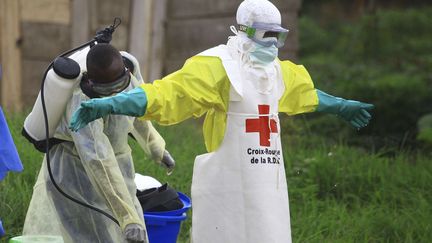 Un agent de santé asperge de désinfectant l'un de ses collègues dans un centre de traitement&nbsp;d'Ebola le 9 septembre 2018.&nbsp; (AL-HADJI KUDRA MALIRO/AP/SIPA / AP)