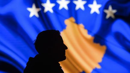 Un homme devant le drapeau du Kosovo. (ARMEND NIMANI / AFP)