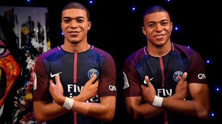 L'attaquant des Bleus et du Paris Saint-Germain Kylian Mbappé à côté de sa statue de cire au musée Grévin à Paris le 17 mai 2018. (CHRISTOPHE SIMON / AFP)