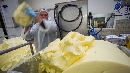 Un ouvrier manipule du beurre dans une laiterie à Echiré (Deux-Sèvres), le 17 mars 2015. (GUILLAUME SOUVANT / AFP)