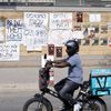 Un livreur passe devant des affiches réclamant le retour des otages détenus par le Hamas, à Tel-Aviv, en Israël, le 22 octobre 2023. (NIR KEIDAR / ANADOLU / AFP)