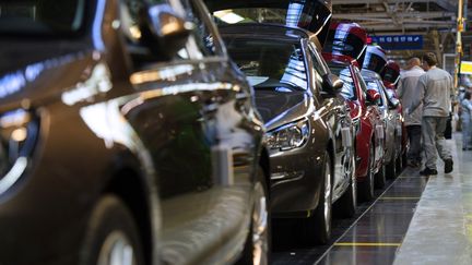 Des ouvriers assemblent des Peugeot 308 sur une cha&icirc;ne de montage de l'usine&nbsp;PSA Peugeot Citro&euml;n de Sochaux (Doubs), le 6 mars 2014. (SEBASTIEN BOZON / AFP)