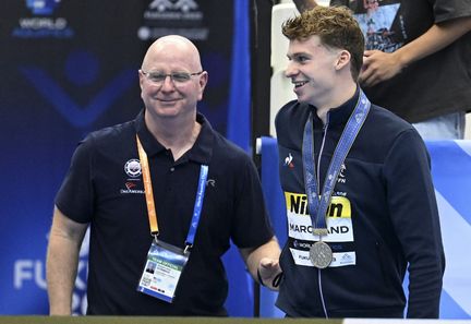 Bob Bowman et Léon Marchand à l'occasion des Mondiaux de natatioin de Fukuoka (Japon), le 23 juillet 2023. (STEPHANE KEMPINAIRE / AFP)