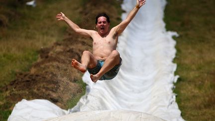 Descente d'un waterslide g&eacute;ant &agrave; l'occasion d'un &eacute;v&eacute;nement caritatif organis&eacute; &agrave; Waimauku (Nouvelle-Z&eacute;lande), le 23 f&eacute;vrier 2013. (PHIL WALTER / GETTY IMAGES)