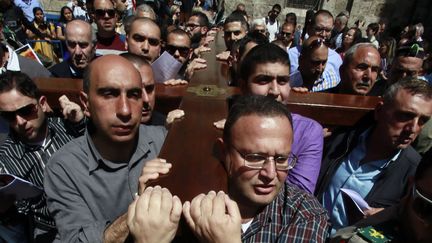 Des Arabes catholiques portent une croix en bois le long de la "Via Dolorosa" (le chemin de la souffrance) dans la vieille ville de J&eacute;rusalem, le 3 avril 2015. (GALI TIBBON / AFP)