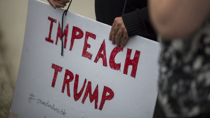 Un manifestant tient une pancarte pour demander la destitution de Donald Trump, le 10 mai 2017 à Los Angeles (Californie) aux Etats-Unis. (DAVID MCNEW / AFP)